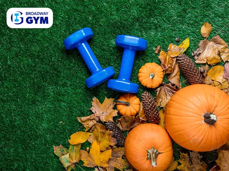 Blue dumbbells and autumn leaves with pumpkin