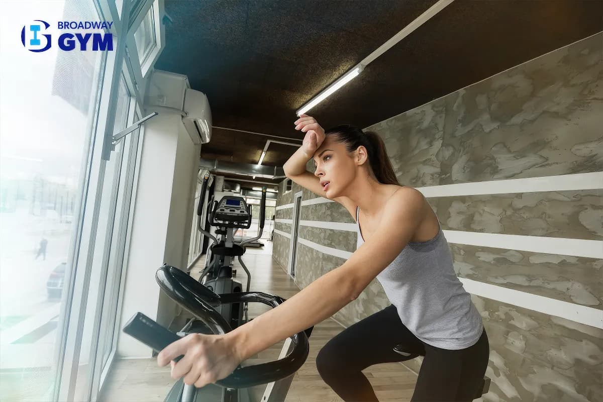 Woman doing cardio exercises with Broadway Gym's logo on it